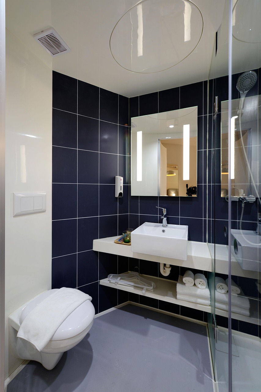 Luxury spa-like bathroom renovation with navy tile, floating vanity, and LED mirror in Richmond, Virginia