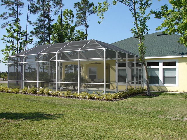 Beautiful screened sunroom addition with white aluminum framing seamlessly integrated with existing home in Virginia